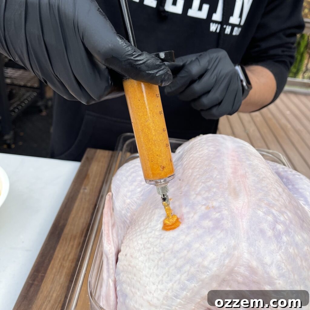 Ultimate Deep Fried Turkey 4 Injecting a turkey with a flavorful marinade.