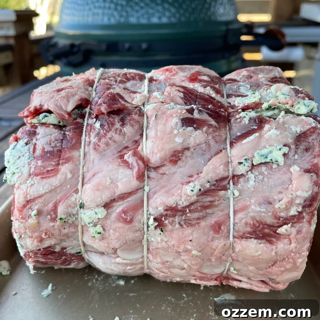 Raw prime rib meticulously tied with butcher's twine, ready for the grill.