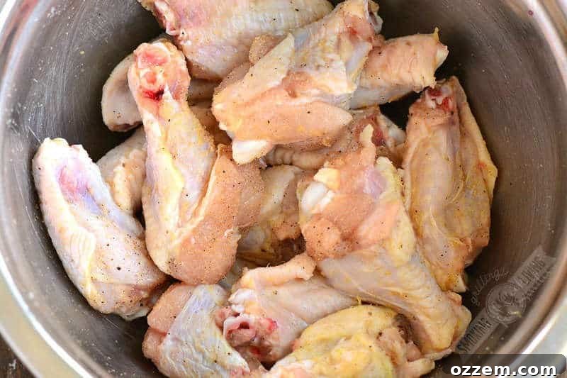 seasoned raw chicken wings in a mixing bowl