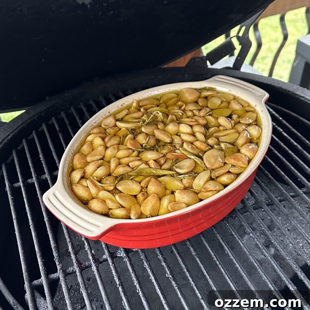 Garlic confit cooking in a heat-safe dish on a grill, surrounded by indirect heat.