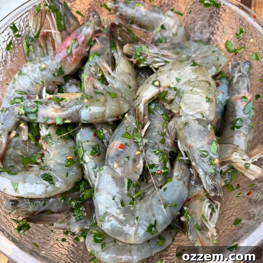 Marinated whole shrimp skewers, coated in green chimichurri, ready for the grill.