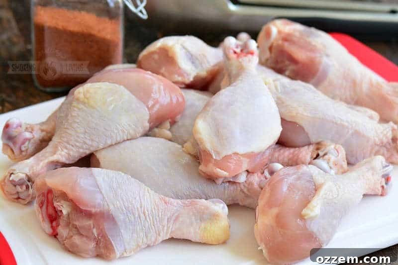 raw chicken drumsticks laid out on a cutting board, ready for seasoning