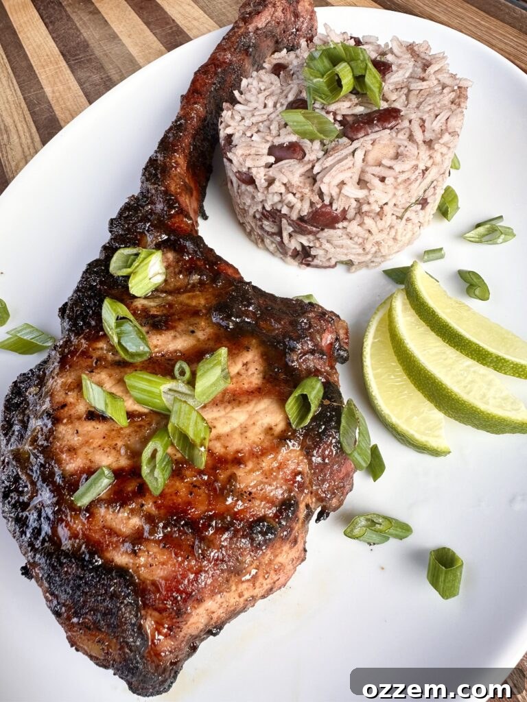 Perfectly grilled Jerk Pork Chops with a vibrant, spicy glaze, served alongside aromatic Jamaican rice.