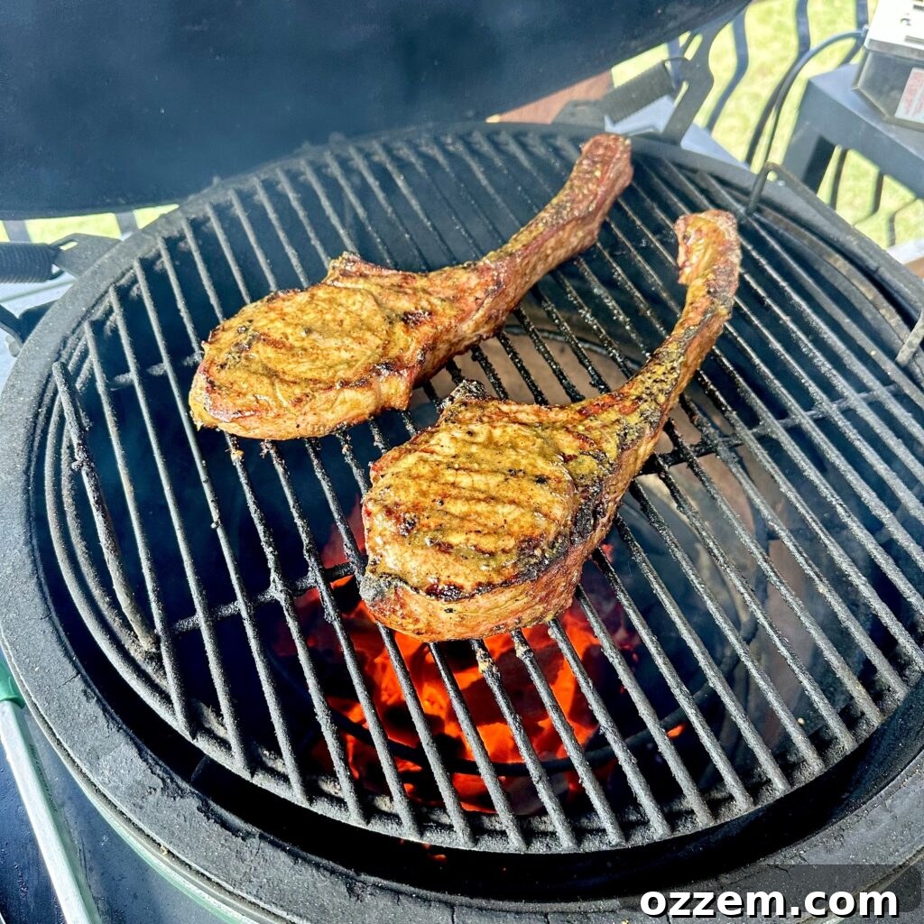 Jerk pork chops sizzling on a hot grill, showing a perfect char.