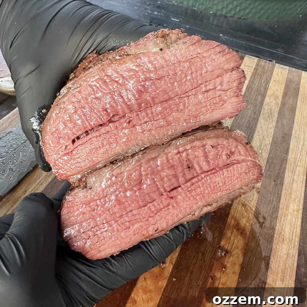 Perfectly seared and rested tri tip steak on a wooden cutting board, ready to be sliced.
