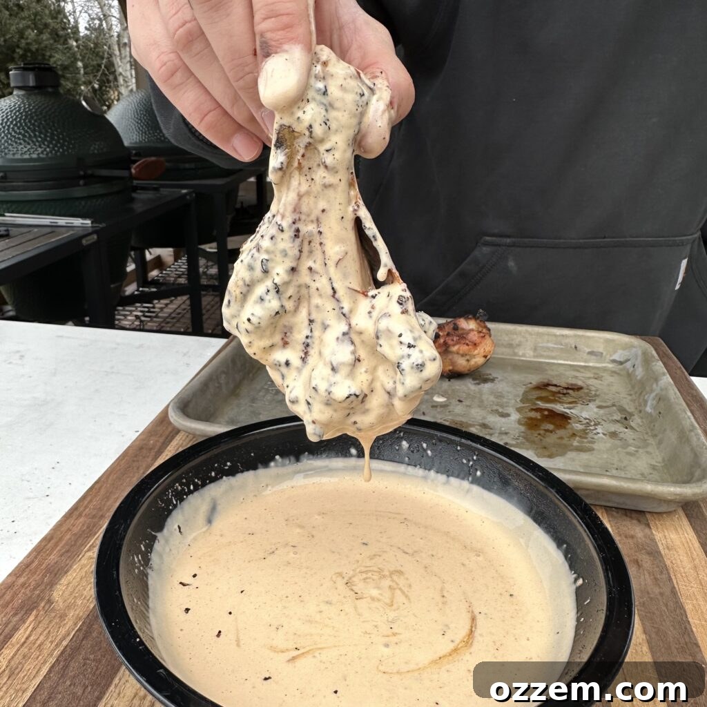 Bowl of creamy Alabama white sauce with a whisk