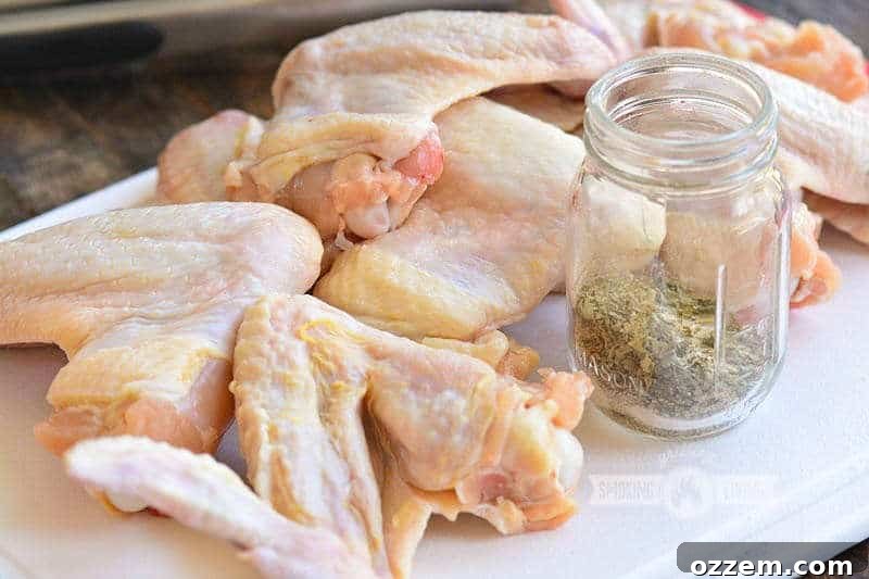 raw wings on the cutting board with seasoning in a jar