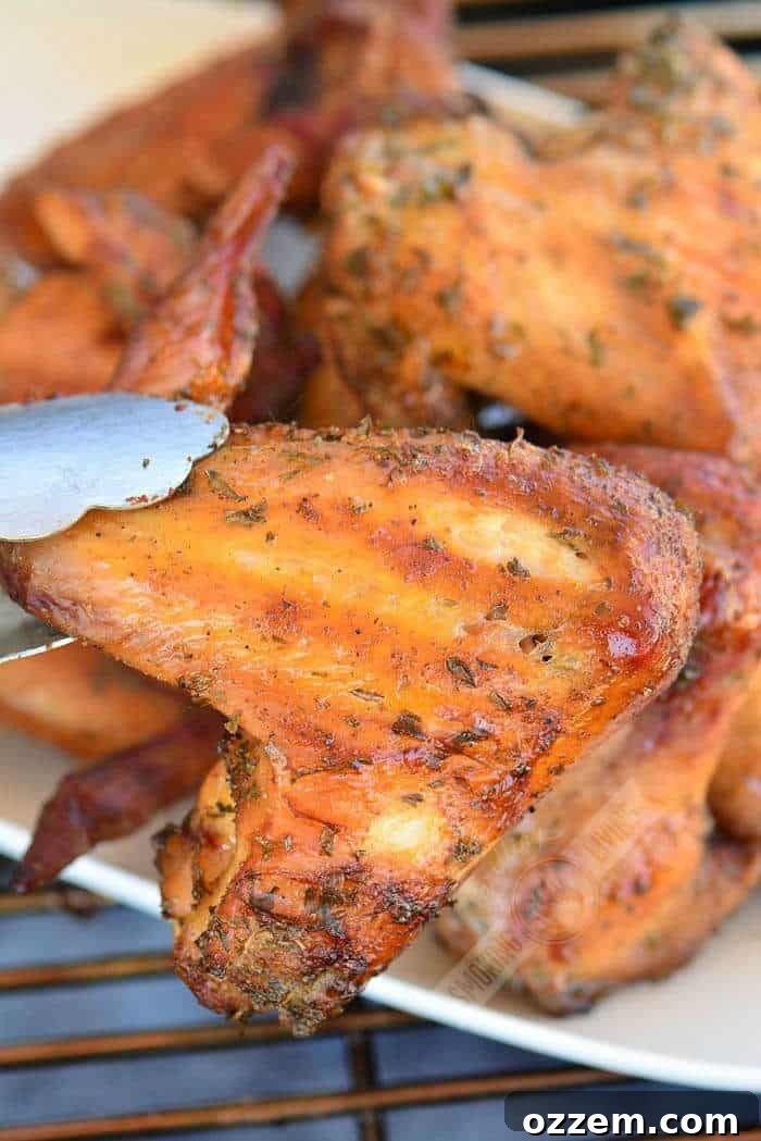 holding a chicken wings with metal tongues
