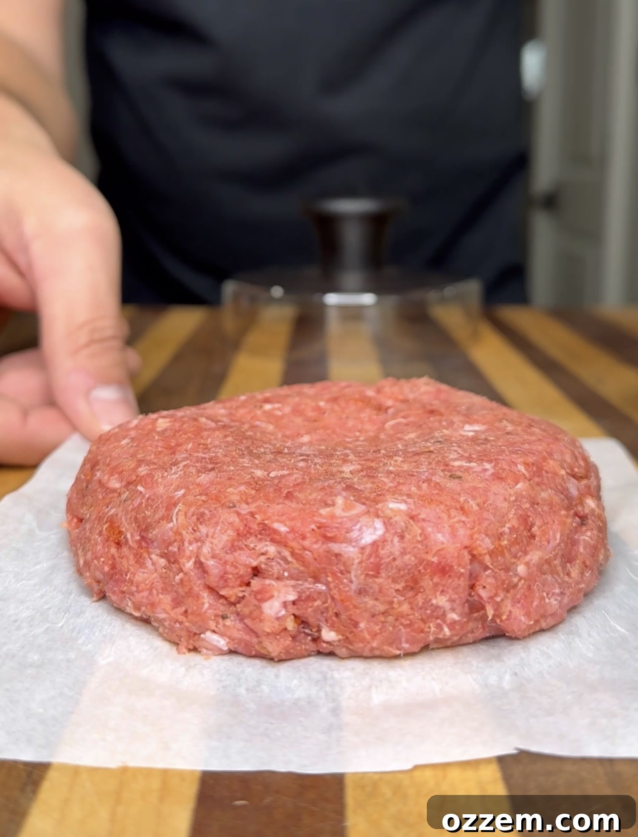 Perfectly formed, raw beef patty ready for grilling