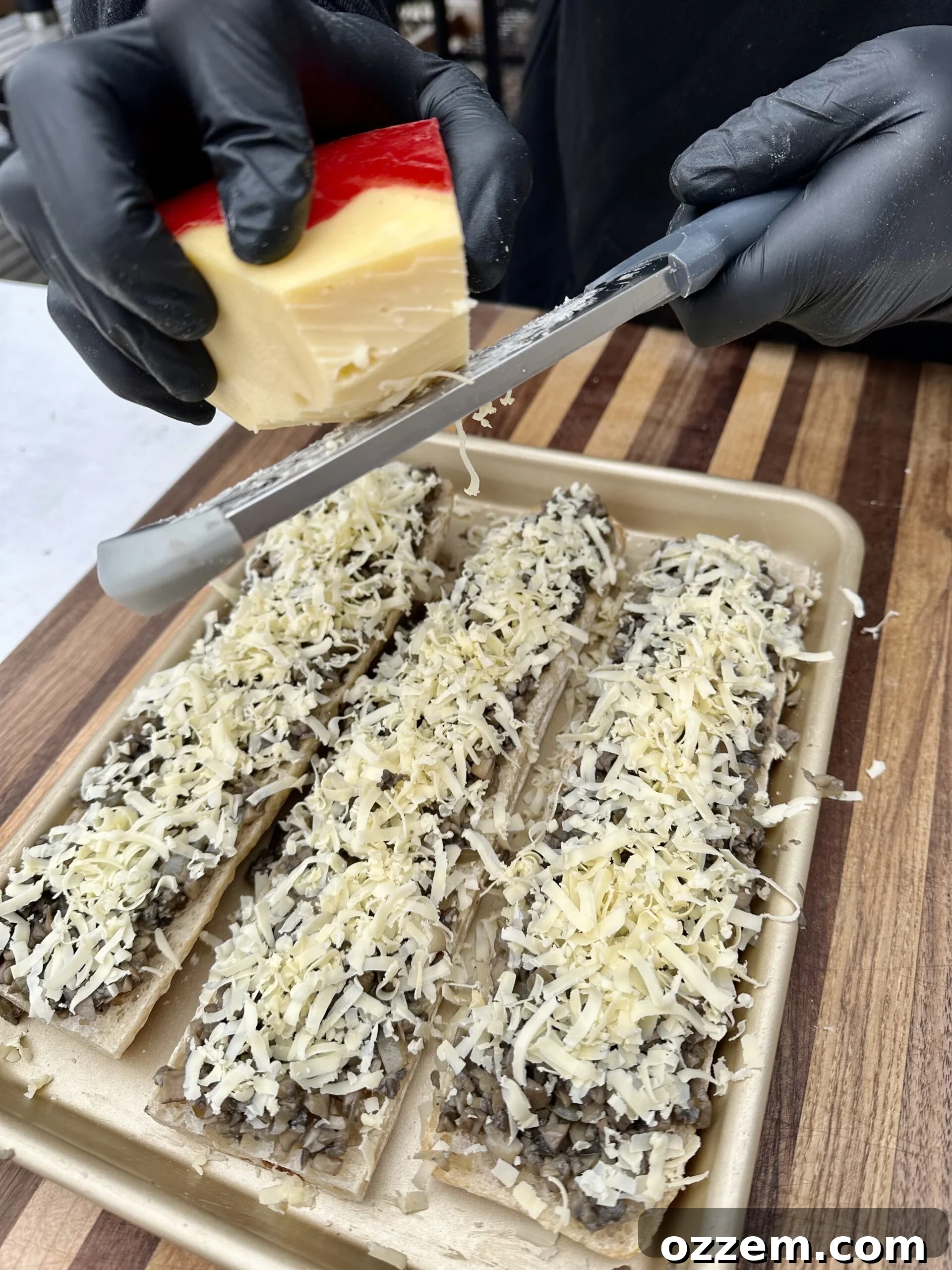 Shredded Gouda cheese generously topping the Zapiekanka