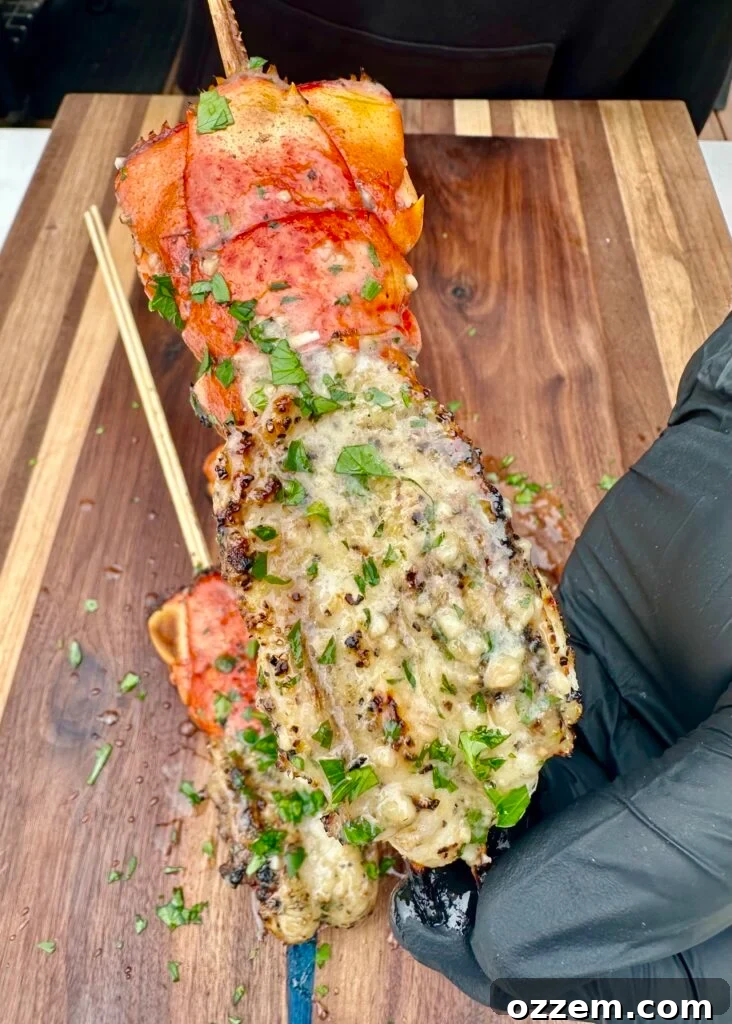 Perfectly grilled lobster skewers glistening with lemon parmesan butter sauce, ready to be served.