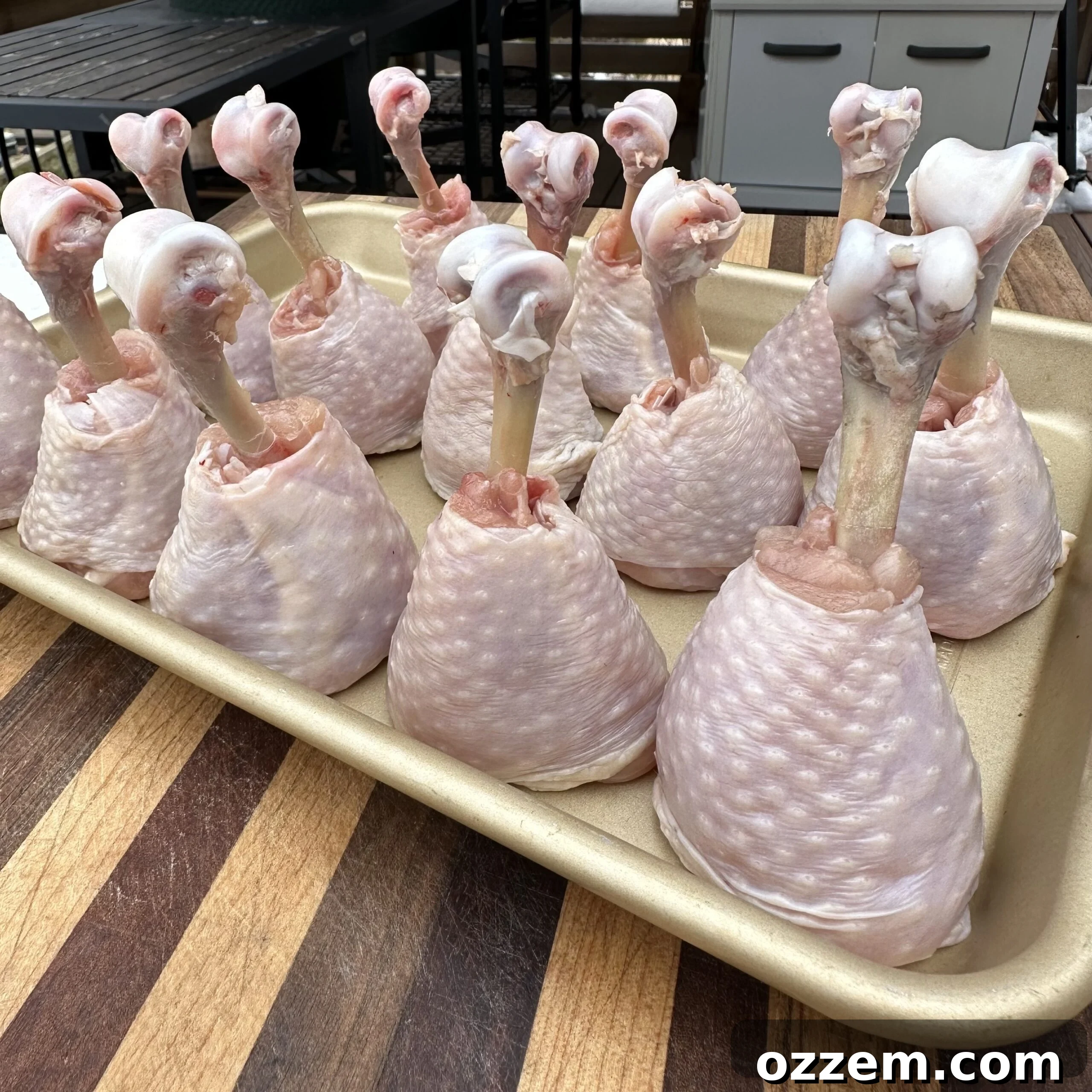 Clearly shaped chicken lollipops ready for seasoning and grilling.