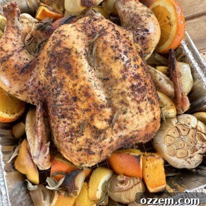 A vibrant, golden-brown roasted citrus chicken in a roasting pan, garnished with fresh herbs and citrus slices.