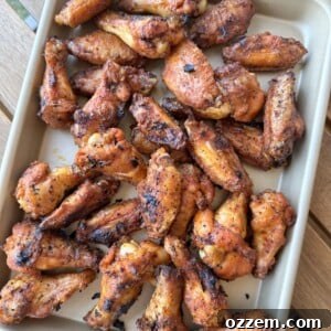 Close-up of perfectly grilled dry rub chicken wings, golden-brown and crispy, served hot and ready to eat.