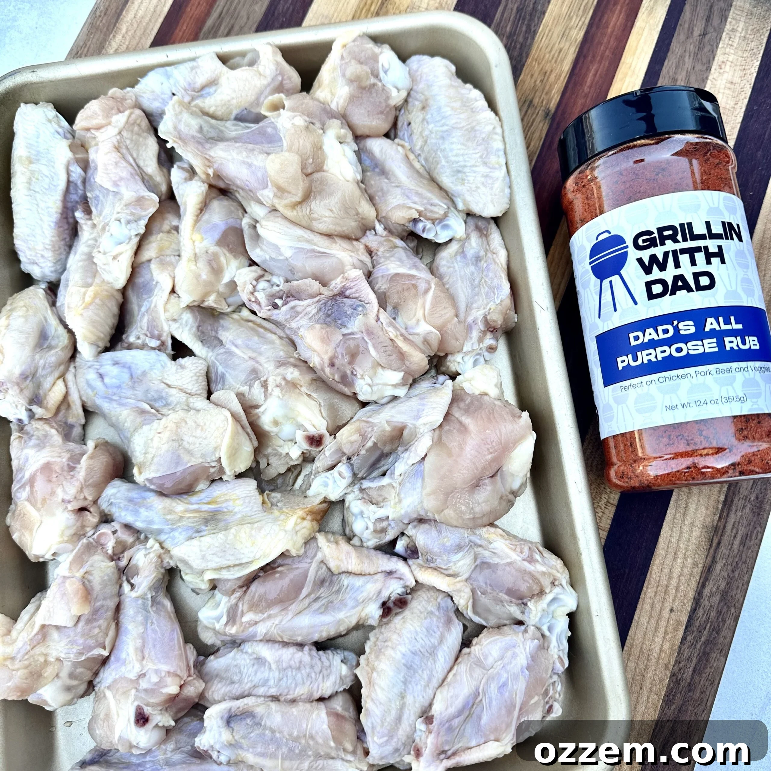 A selection of raw chicken wing pieces, olive oil, and dry rub seasoning, perfectly laid out for the initial preparation steps.