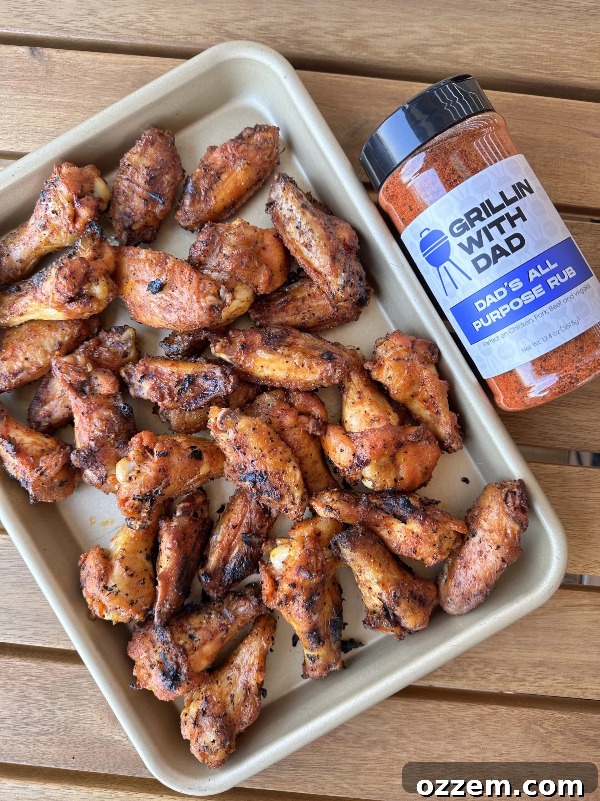 A pile of golden-brown, crispy dry rub chicken wings, glistening and ready to be enjoyed, showcasing their perfect grill marks.