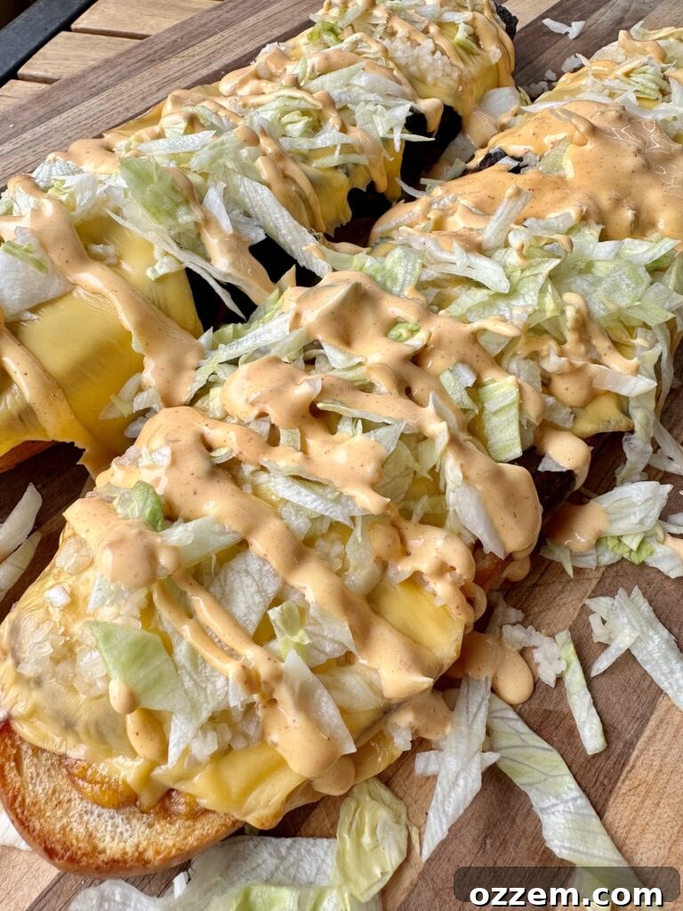 Grilled and assembled long mac sandwich, showcasing its layers of beef, cheese, and fresh toppings