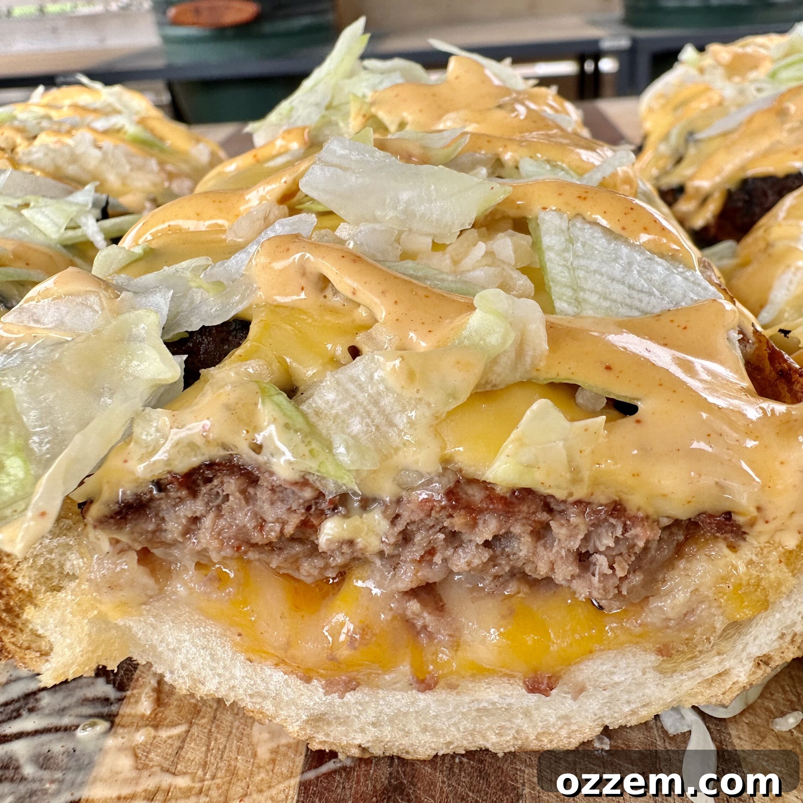 The finished, cooked, and topped Grilled Long Mac on a wooden cutting board, sliced into serving portions