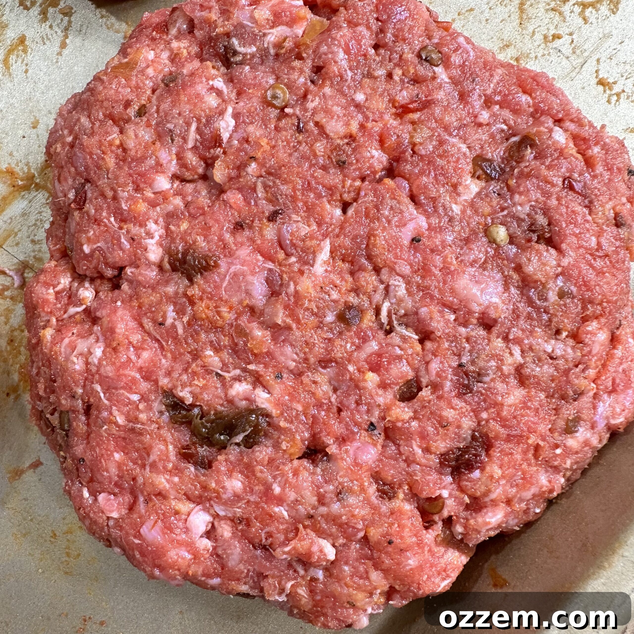 Raw, seasoned chipotle beef patties, ready for grilling.