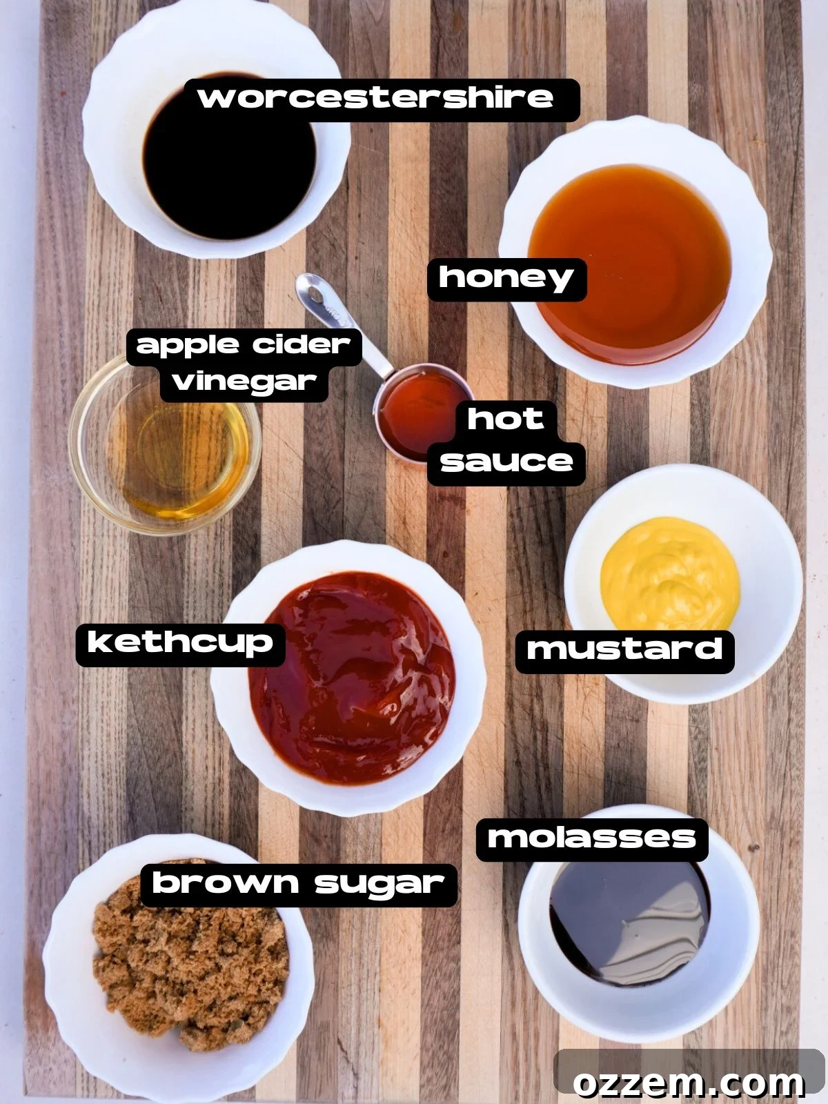 Bowls on a cutting board displaying all the essential ingredients for a sweet and tangy homemade BBQ sauce.