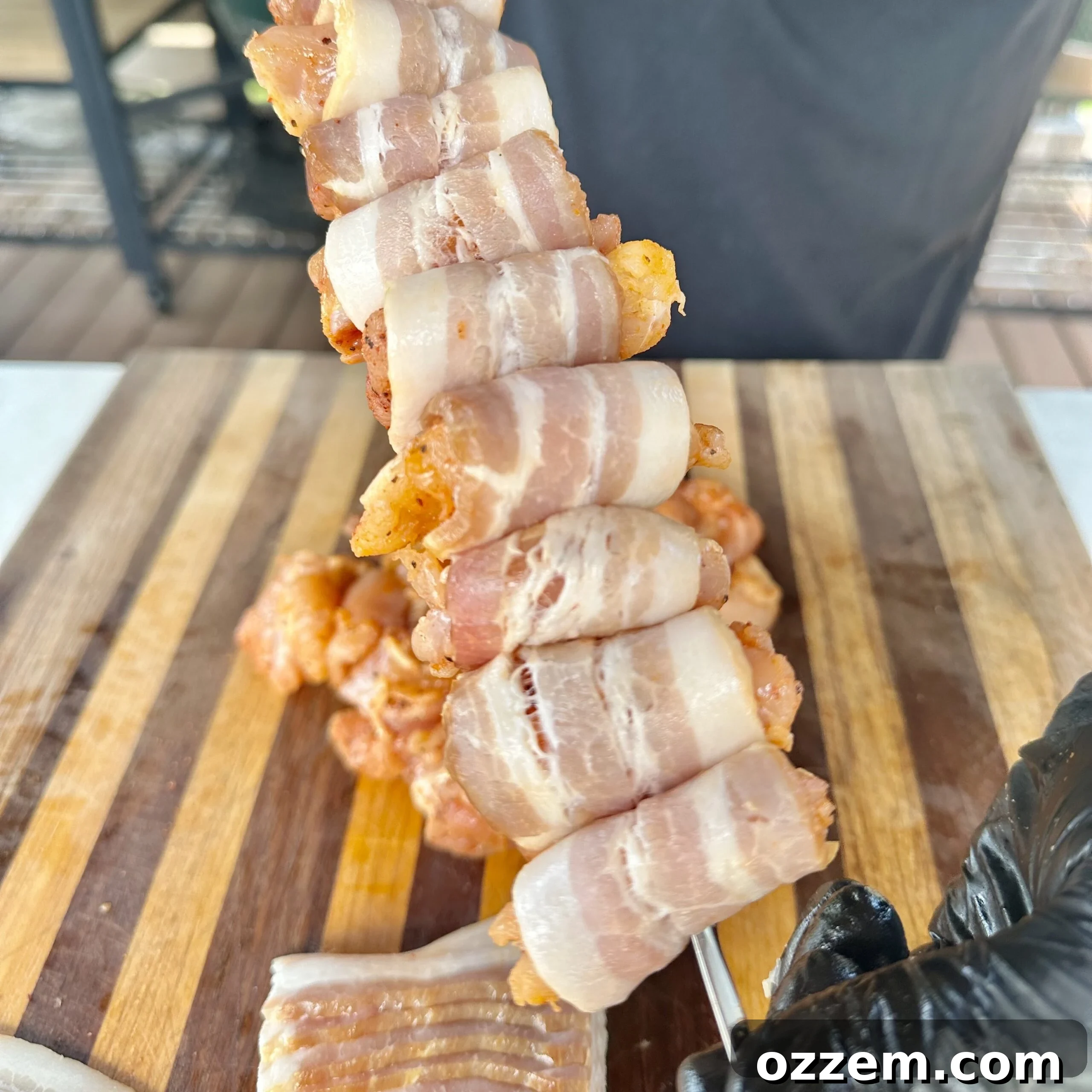 Bacon-wrapped chicken pieces threaded onto metal skewers.