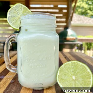A tall glass of creamy Brazilian Lemonade with a lime slice garnish.