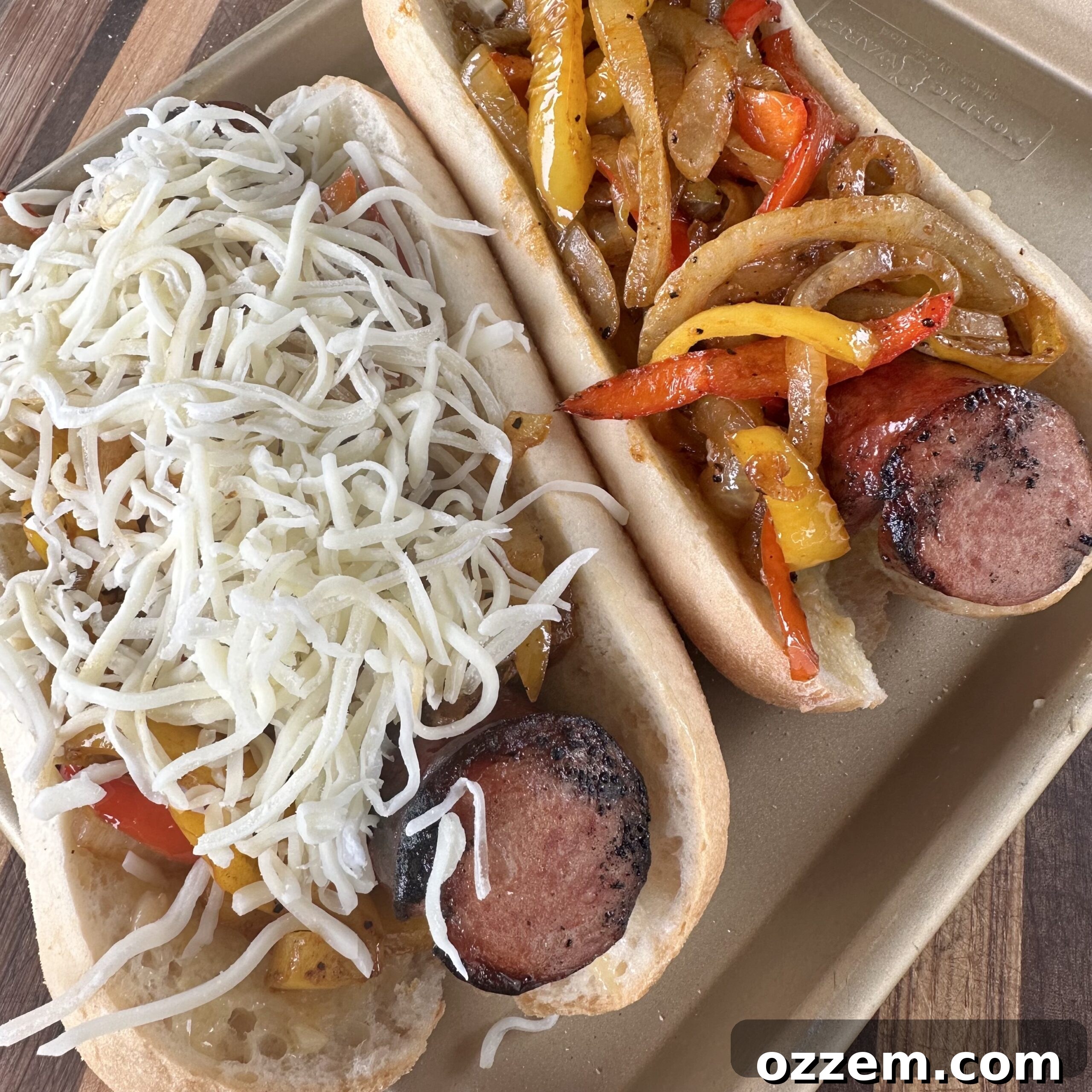 A step-by-step image showing grilled sausages being placed into a toasted roll, topped with sautéed vegetables and shredded cheese.