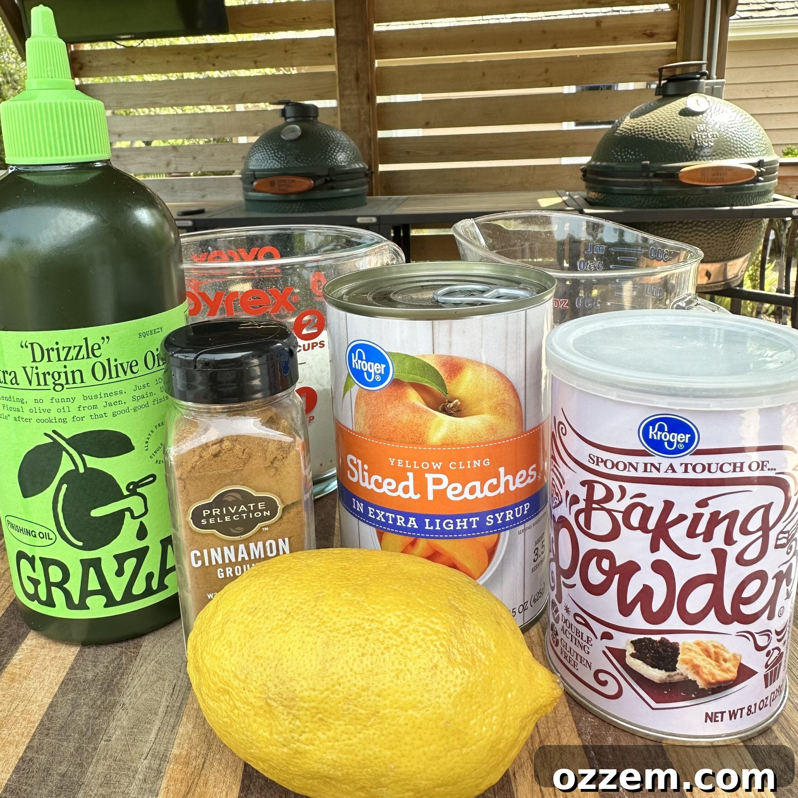 Fresh ingredients laid out for grilled peach cobbler, including canned peaches, lemons, sugar, flour, and spices.