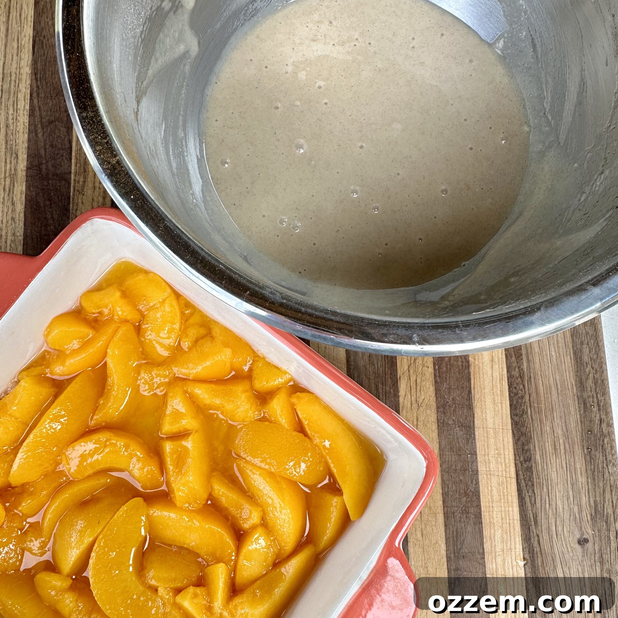 Mixing the cobbler batter in a bowl, showing the smooth consistency before it's poured over the peaches.