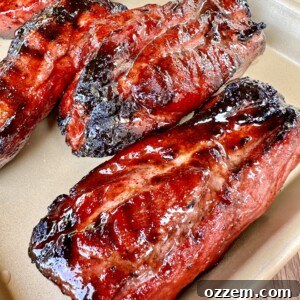 Finished Chinese BBQ Pork (Char Siu) on a plate, sliced and garnished.