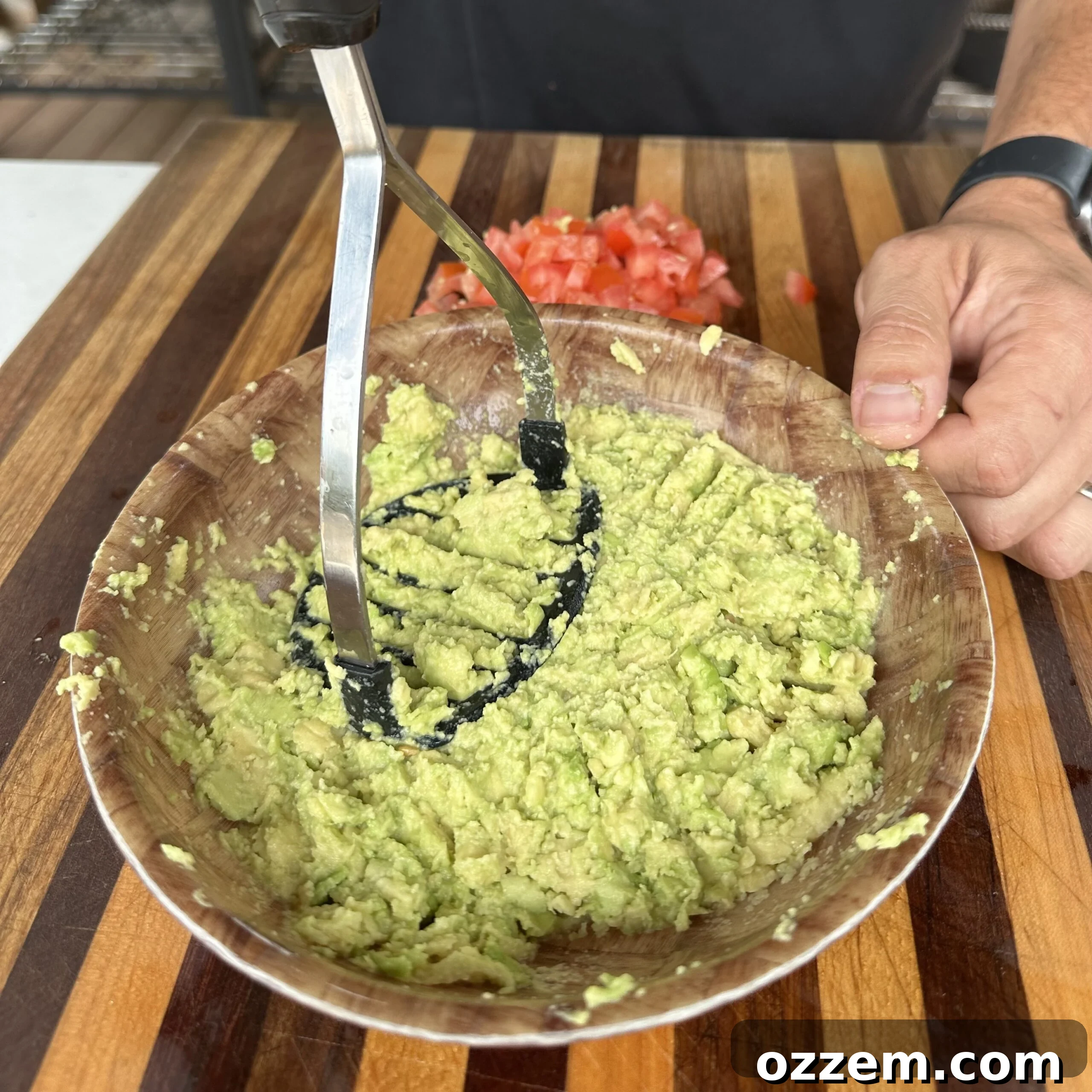 Fresh homemade guacamole in a bowl with ingredients