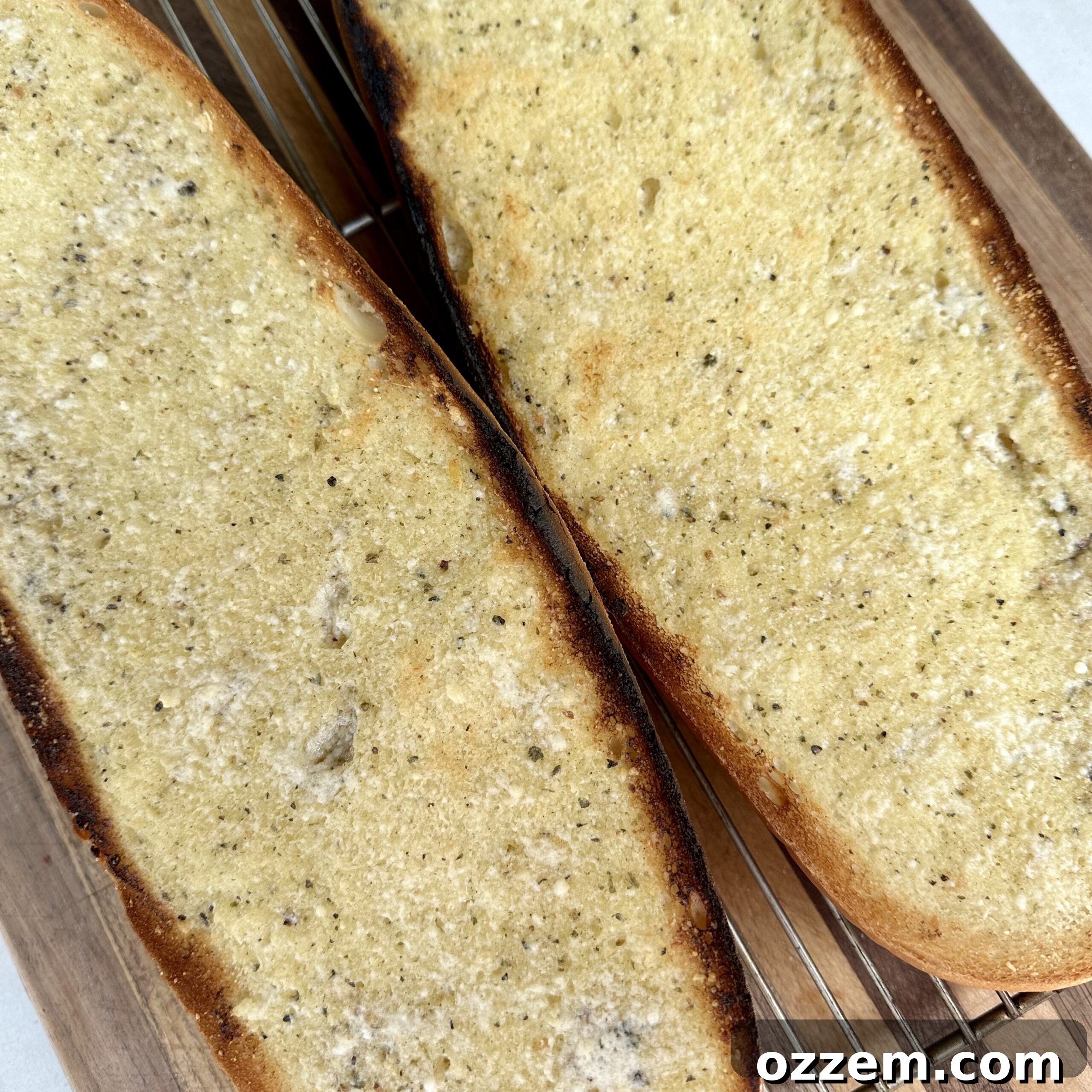 French bread halves spread with homemade garlic butter, ready for the oven.