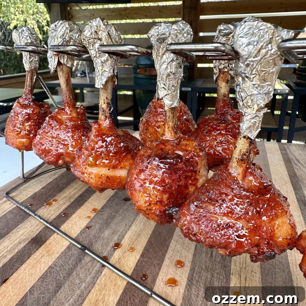 Bourbon Peach Chicken Lollipops 2 Perfectly grilled peach and whiskey chicken lollipops on a serving platter, glistening with glaze.