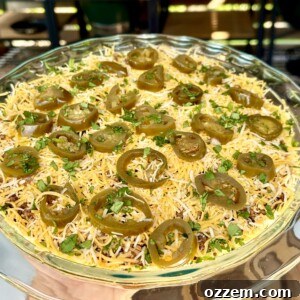 A top-down view of a colorful eight-layer taco dip, garnished and ready to serve.