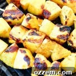 pineapple chunks on skewers on the grill