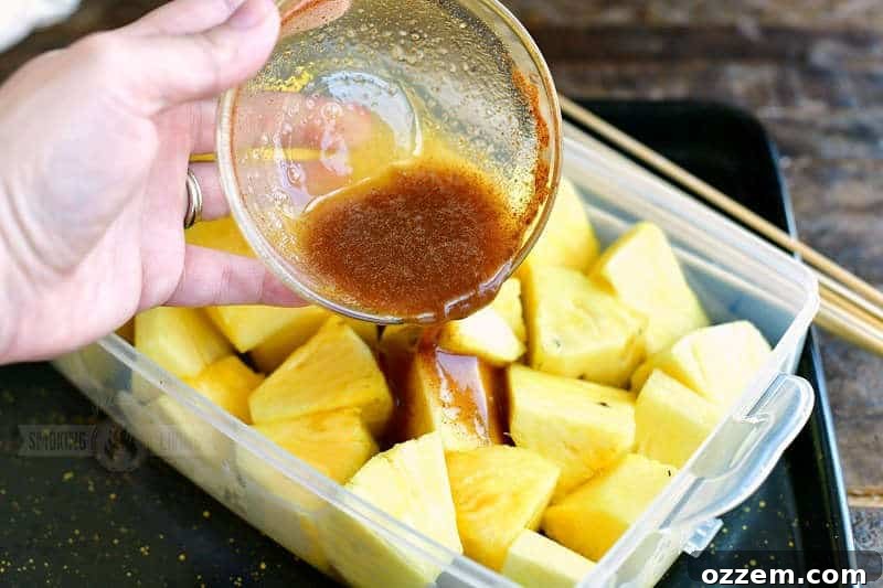 pouring brown sugar mixture over pineapple chunks in a plastic container