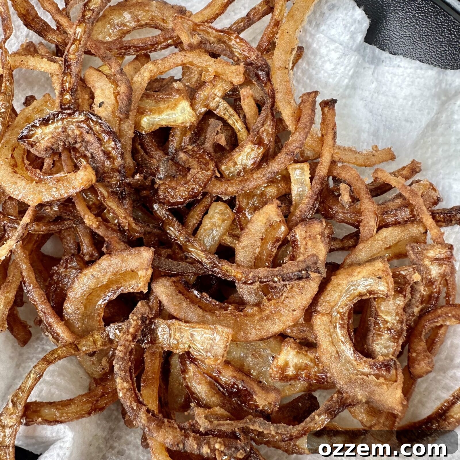 Onion strips coated in flour and seasoning, ready for frying.