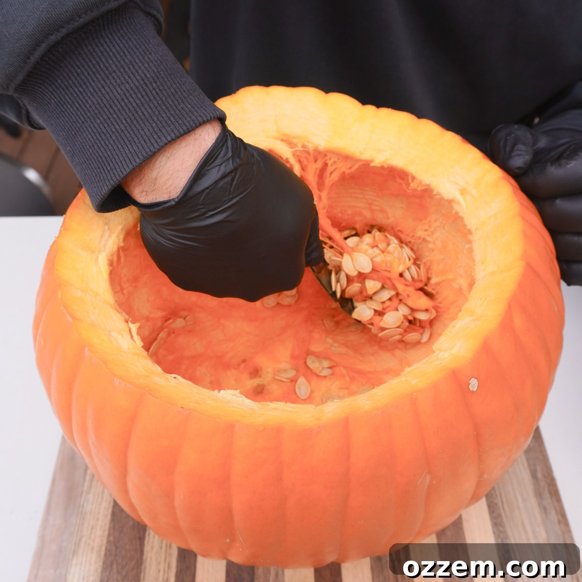 a pumpkin being hollowed out for cooking