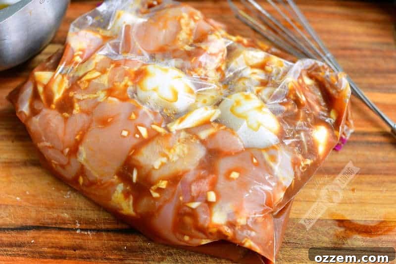 Chicken and sliced onions marinating in homemade teriyaki sauce inside a gallon zip-lock bag in the refrigerator.