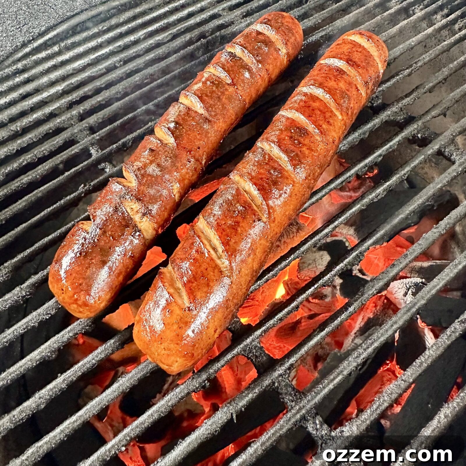 Perfectly grilled hotdogs with score marks, showing a crispy exterior and ready for assembly.