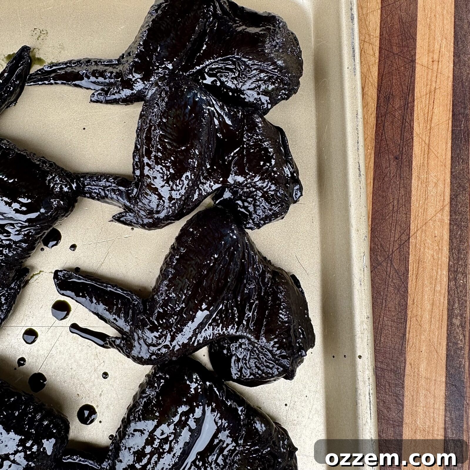 Marinated black Bat Wings arranged on a grill grate, ready to be cooked to crispy perfection.