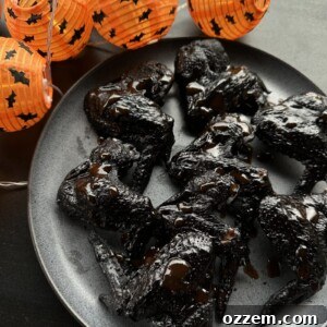 Close-up of a stack of dark, grilled Bat Wings ready to be served on a platter.