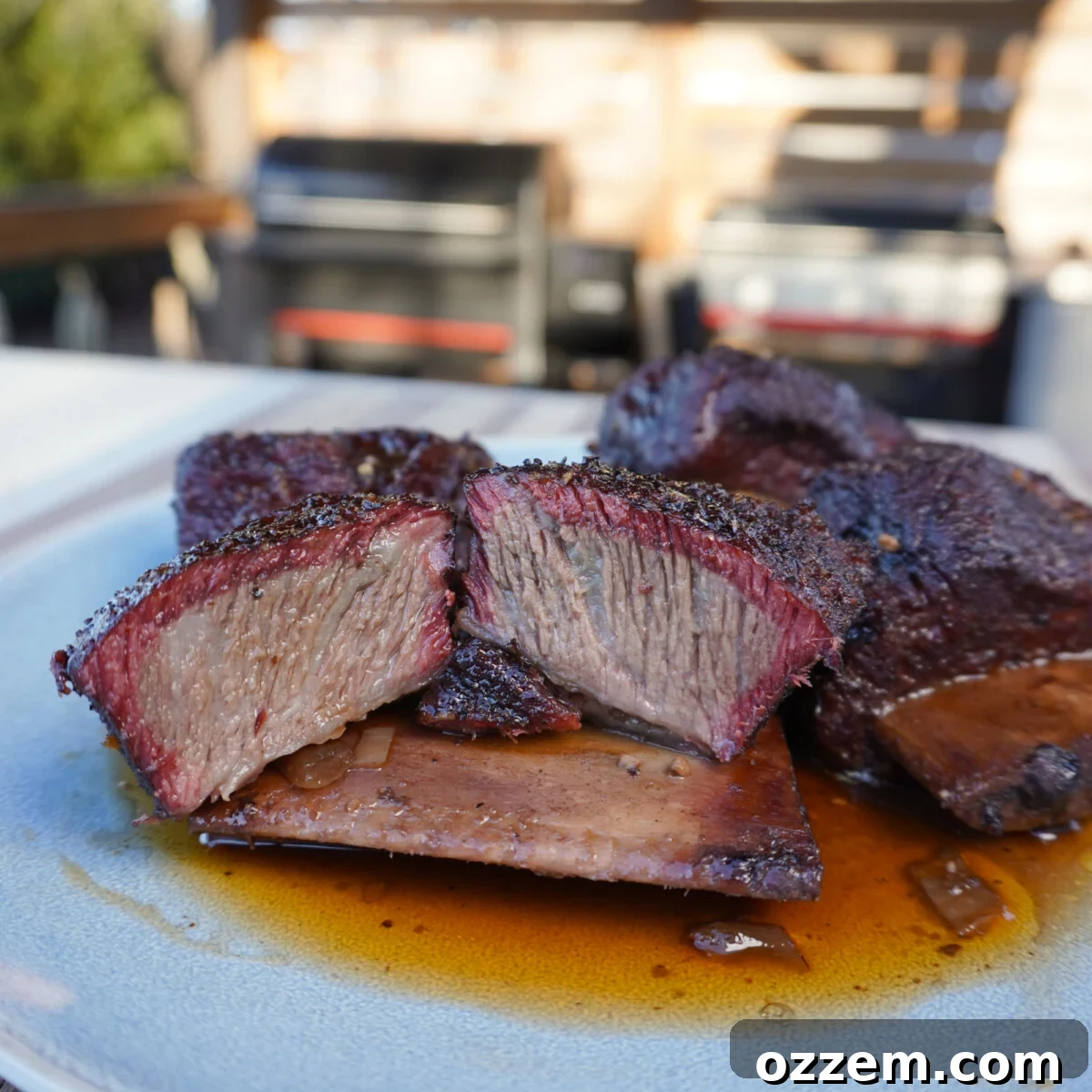 Velvet Smoke Ribs 2 Perfectly smoked short ribs, cut in half on a rustic plate, ready to be served.