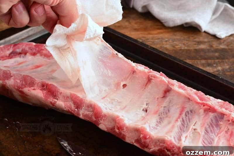 pulling the membrane off the bottom of the rack of baby back ribs