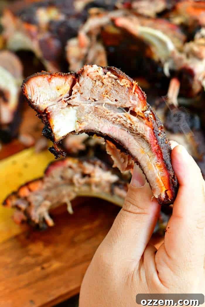 holding one smoked rib with other ribs on the background