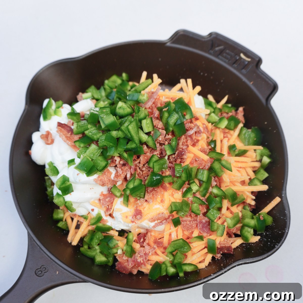 Cast iron skillet filled with all the raw ingredients for a dip.