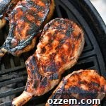 Four grilled pork chops on the grill