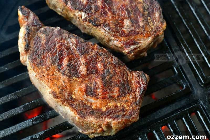 seared steak cooking on the grill grate