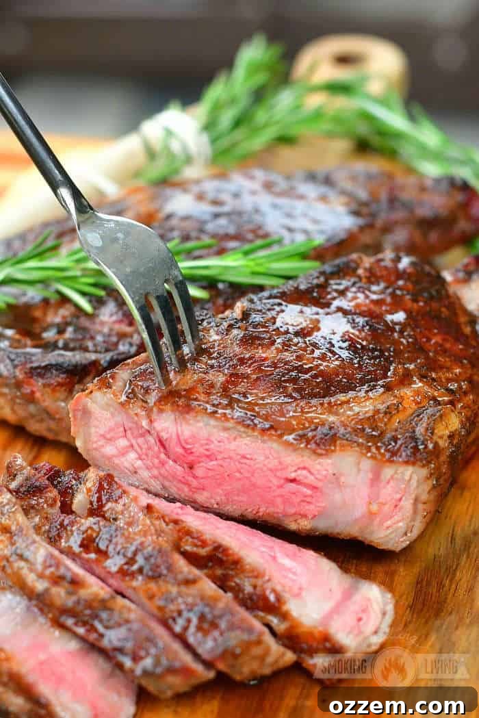 cut medium-rare steak on the cutting board with a fork in it and some sliced off steak near