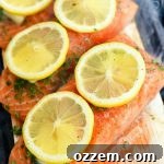 uncooked salmon fillets with lemon and herbs on top on a wooden plank
